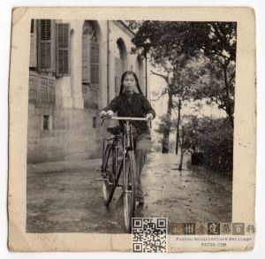 1950-1960年代，一位少女在爱国路2号建筑前牵着自行车留影。该建筑当时可能为邮政宿舍（来源：林轶南收藏）